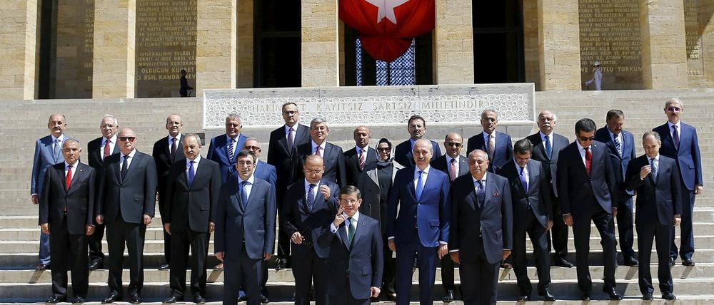 Der türkische Übergangspremier Ahmet Davutoglu posiert mit seinen frisch vereidigten Minister vor dem Atatürk-Mausoleum. Ayse Gürca, Mitte, ist die einzige Frau im Kabinett und die erste türkische Ministerin, die ein Kopftuch trägt.