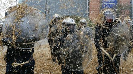 Abwehr. Die Polizei in Brüssel bringt sich gegen fliegende Heuballen in Stellung.