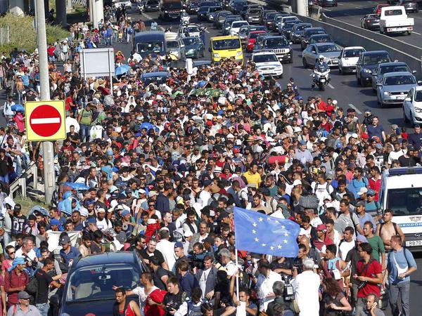 Hunderte Flüchtlinge machen sich zu Fuß auf den Weg von Ungarn nach Österreich über die Autobahn.