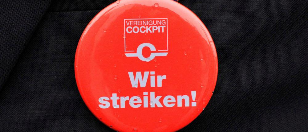 Ein Lufthansa-Pilot mit Streik-Button. Die Pilotenvereinigung Cockpit bestreikt am Dienstag zunächst Langstreckenflüge.