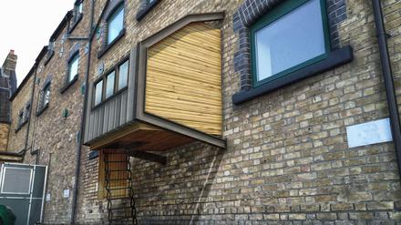 Eine Illustration des Architekten James Furzer zeigt die Holzkästen, die der 26-Jährige für Obdachlose an Hauswänden in London anbringen möchte. 