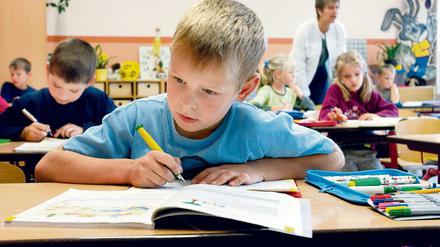 Schüler sitzen im Klassenraum vor ihren Schreibheften.