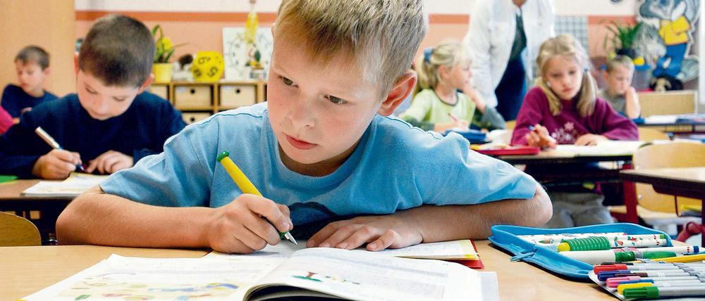 Schüler sitzen im Klassenraum vor ihren Schreibheften.