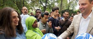 Gute Tat. Berlins Justizsenator Thomas Heilmann (CDU) übergibt im AWO-Refugium in Berlin Fußbälle und Hertha-Tickets an Flüchtlinge aus dem Kosovo und Somalia. 