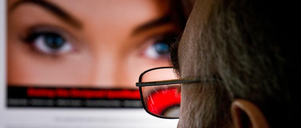 Ein Mann schaut sich im Internet das Seitensprungportal Ashley Madison an. Die Seite wurde gehackt und Daten von Nutzern ins Internet gestellt. 