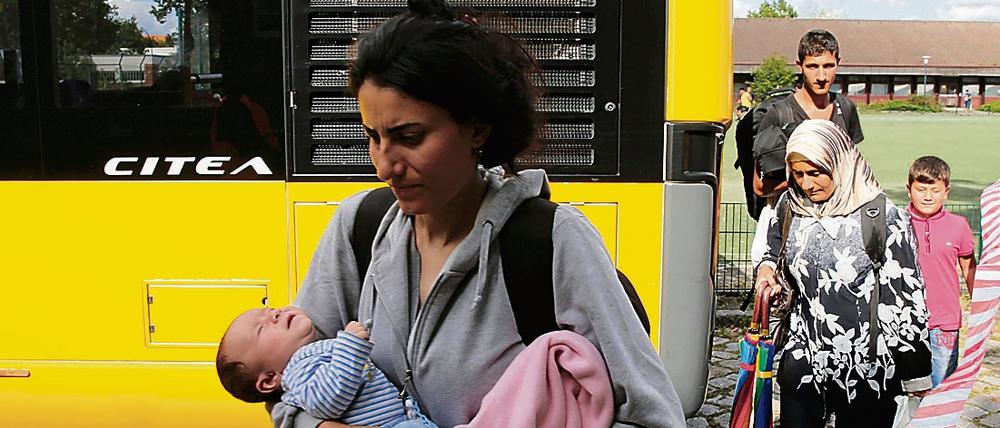 Flüchtlinge erreichen am Montag die Flüchtlingsunterkunft in Spandau.