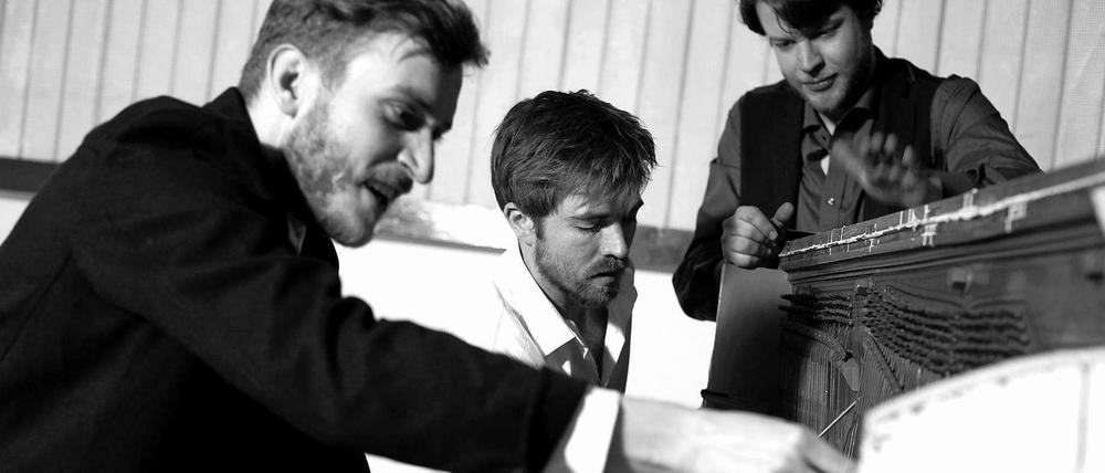 Brandt Brauer Frick bearbeiten ein Klavier.