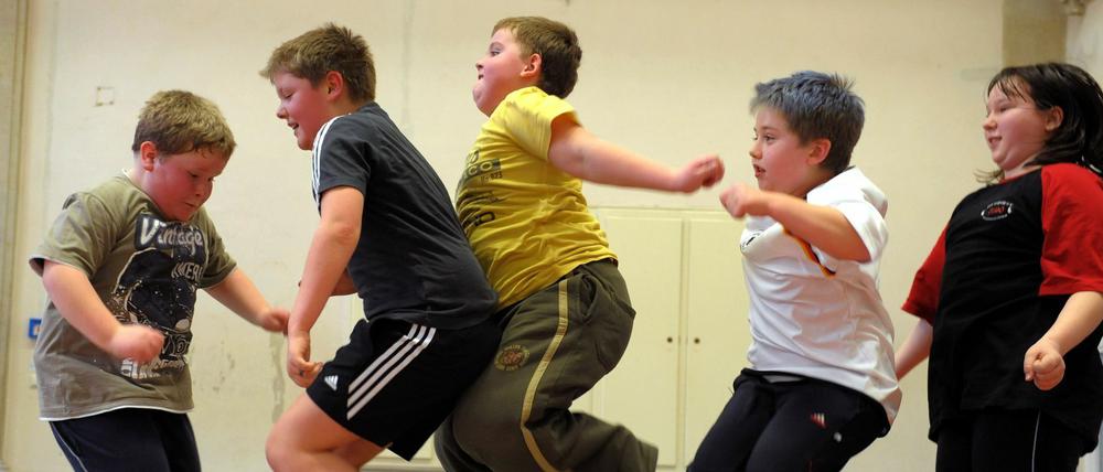 Übergewichtige Kinder nehmen in einer Sporthalle in Leipzig an einem Sportprogramm teil.