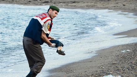 Ein toter Junge wird von einem türkischen Polizisten weggetragen.