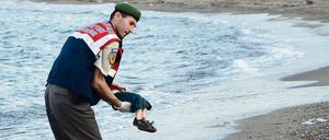 Ein toter Junge wird von einem türkischen Polizisten weggetragen.