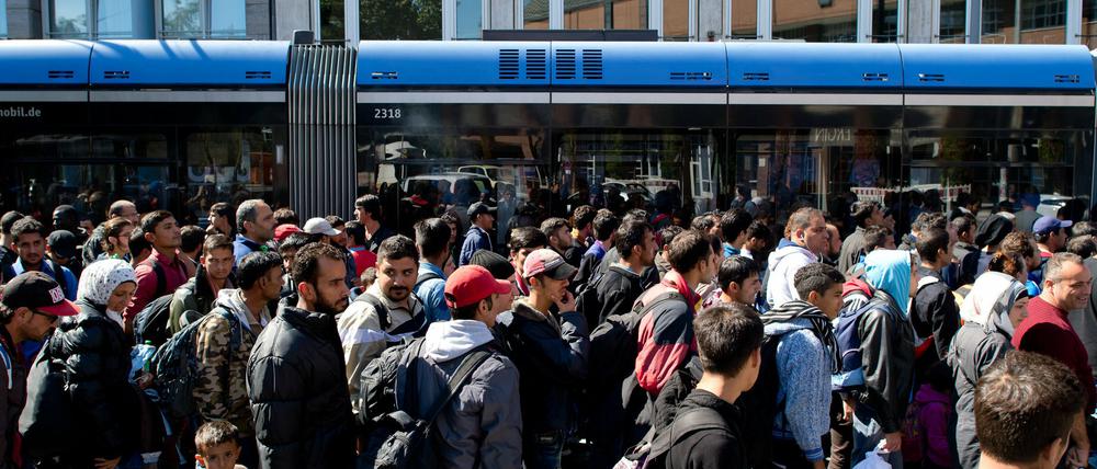 Flüchtlinge, die kurz zuvor mit Zügen angekommen sind, werden am 12.09.2015 vom Hauptbahnhof in München (Bayern) zu einer Unterkunft begleitet.