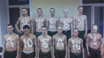 Junge Männer mit russischen Buchstaben auf den nackten Oberkörper gemalt