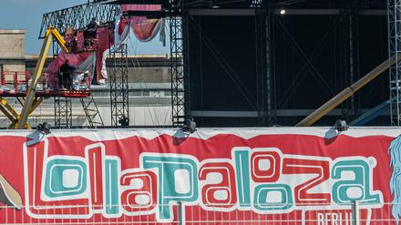 Ein Arbeiter auf einer Hebebühne montiert auf dem Gelände des ehemaligen Flughafen Tempelhof ein Transparent für das US-Festival Lollapalooza.