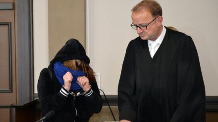 Die Angeklagte und ihr Anwalt Jochen Zersin stehen am Dienstag im Landgericht in Verden (Niedersachsen) im Verhandlungssaal. Weil sie sich nicht um eine sterbende Frau gekümmert haben, stehen seit Dienstag der Ehemann und die Tochter der 49-Jährigen wegen Mordes vor Gericht. Die Staatsanwaltschaft wirft ihnen Mord durch Unterlassen vor.