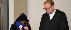 Die Angeklagte und ihr Anwalt Jochen Zersin stehen am Dienstag im Landgericht in Verden (Niedersachsen) im Verhandlungssaal. Weil sie sich nicht um eine sterbende Frau gekümmert haben, stehen seit Dienstag der Ehemann und die Tochter der 49-Jährigen wegen Mordes vor Gericht. Die Staatsanwaltschaft wirft ihnen Mord durch Unterlassen vor.