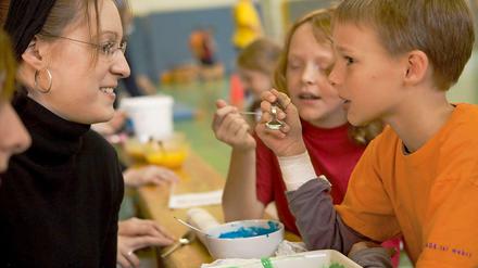 Probieren und studieren: Zwei Kinder testen gefärbten Jogurt beim Projekt "ScienceKids".