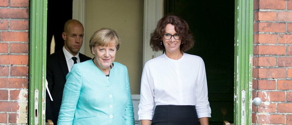 Bundeskanzlerin Angela Merkel (CDU) kommt aus einem Treppenhaus der Ferdinand-Freiligrath-Schule im Stadtteil Kreuzberg zusammen mit der Direktorin Anke Schmidt.