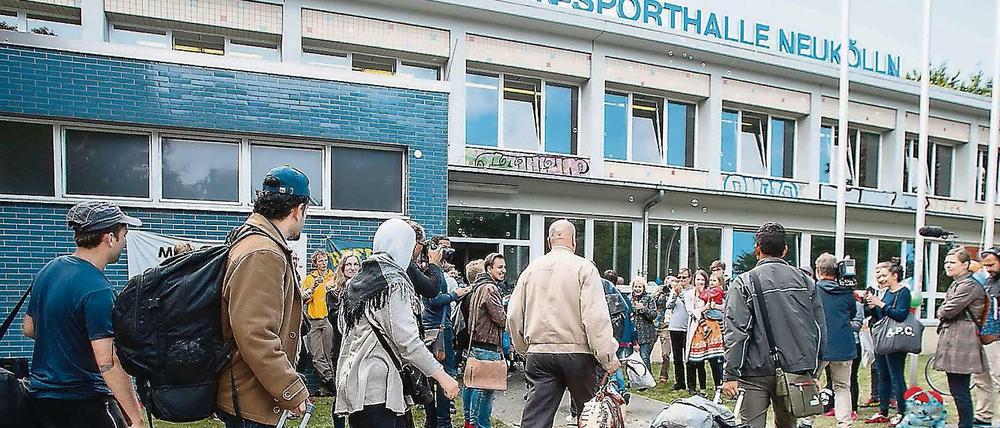 Neue, temporäre Heimat: Flüchtlinge kommen an der Jahnsporthalle am Columbiadamm an.