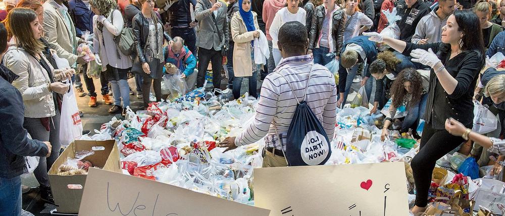 Hunderte Freiwillige bringen Lebensmittel, Getränke und Kleidung in den Hauptbahnhof in Frankfurt am Main, um Flüchtlinge willkommen zu heißen.