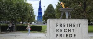 Insellage. Seit 1955 brennt die Ewige Flamme auf dem Theodor-Heuss-Platz, der damals noch Reichskanzlerplatz hieß. Der Blaue Obelisk von Hella Santarossa steht seit 1995 dort.