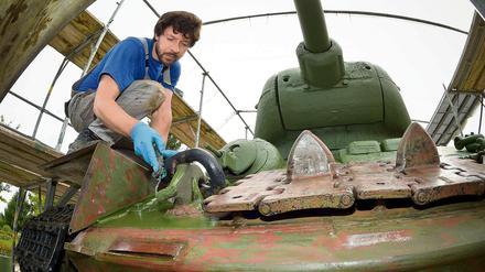 Ein Restaurator einer Berliner Metall-Restaurierungsfirma trägt neue Farbe auf das Denkmal eines russischen Panzers vom Typ T34 in Kienitz (Märkisch-Oderland, Brandenburg) auf.