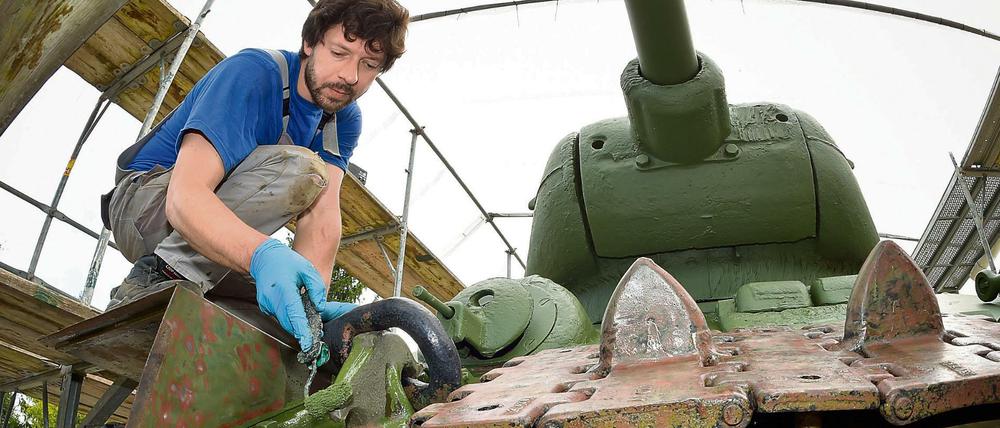 Ein Restaurator einer Berliner Metall-Restaurierungsfirma trägt neue Farbe auf das Denkmal eines russischen Panzers vom Typ T34 in Kienitz (Märkisch-Oderland, Brandenburg) auf. 