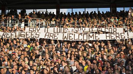 St Pauli-Fans halten ein Banner hoch: "Say it loud say it clear Refugees are welcome here." Der Hamburger Klub verzichtet neben dem FC Union Berlin auf die „Wir helfen“-Aktion für Flüchtlinge der Vereine der 1. und 2. Fußball-Liga. 