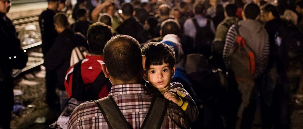 Geht es doch weiter nach Westen? Ein Mann trägt sein Kind am Bahnsteig auf dem Bahnhof des Dorfes Tovarnik in Kroatien auf dem Arm.