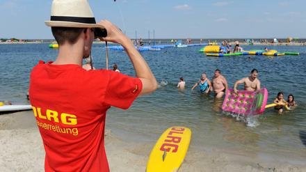 Ein Rettungsschwimmer der DLRG überwacht am 22.08.2015 bei schönstem Sommerwetter die Nordseelagune in Butjadingen (Niedersachsen). Die DLRG vermeldet für den Sommer 2015 deutlich mehr Badetote als noch für 2014. 
