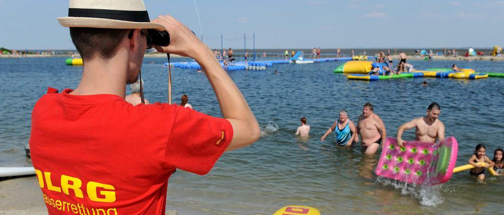 Ein Rettungsschwimmer der DLRG überwacht am 22.08.2015 bei schönstem Sommerwetter die Nordseelagune in Butjadingen (Niedersachsen). Die DLRG vermeldet für den Sommer 2015 deutlich mehr Badetote als noch für 2014.