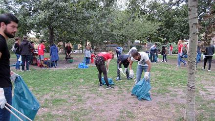 Flüchtlinge der Notunterkunft am Hauptbahnhof säubern gemeinsam mit Freiwilligen der Initiative "Serve the City" den Mauerpark.