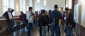 Studierende stehen im Foyer eines Unigebäudes.