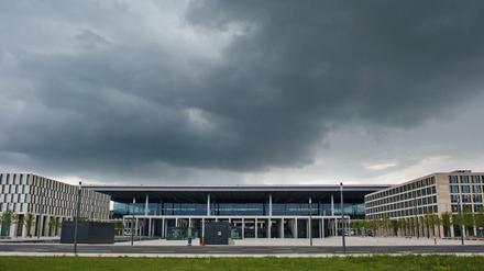 Dunkle Regenwolken liegen über dem Terminal des neuen Flughafens Berlin Brandenburg Willy Brandt (BER) in Schönefeld (Brandenburg).