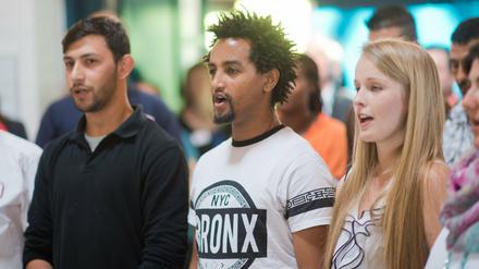 Flüchtlinge und Helfer singen mit einem Flüchtlingschor in der Flüchtlingsunterkunft Oststadtkrankenhaus in Hannover (Niedersachsen). In dem ehemaligen Krankenhaus sind 720 Flüchtlinge aus 33 Nationen untergebracht.