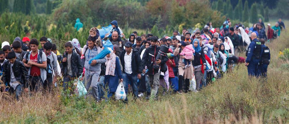 Ungarische Polizei lässt am Sonntag Flüchtlinge aus Serbien zu einem Bahnhof passieren.