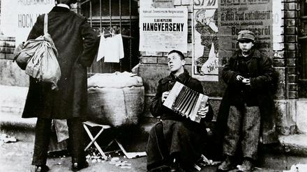 Budapest um 1918: Straßenbettler mit Ziehharmonika