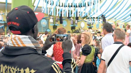 Erinnerungsfoto. Madou ist aus dem Senegal geflohen und zum ersten Mal in einem bayerischen Festzelt. Das Gegröle stört ihn nicht, weil ja alle so fröhlich sind, sagt er. 