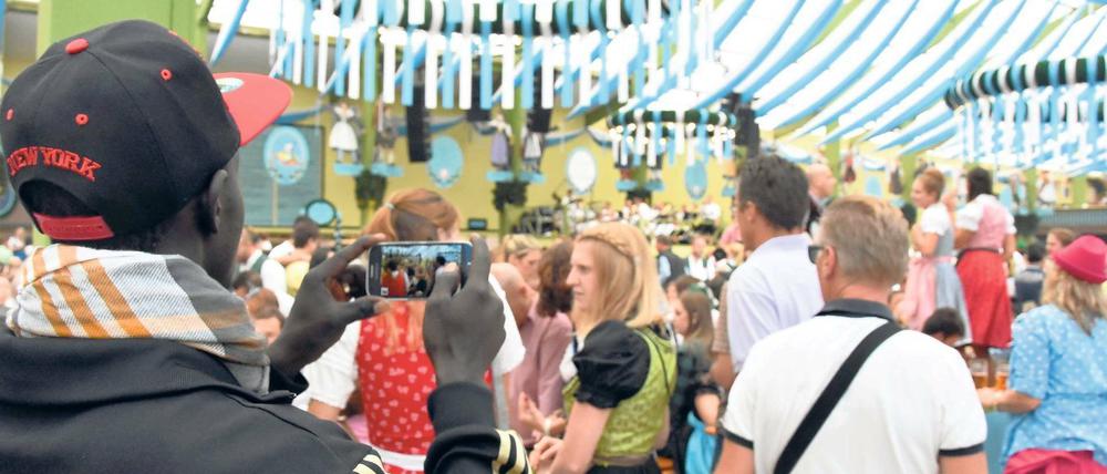 Erinnerungsfoto. Madou ist aus dem Senegal geflohen und zum ersten Mal in einem bayerischen Festzelt. Das Gegröle stört ihn nicht, weil ja alle so fröhlich sind, sagt er. 