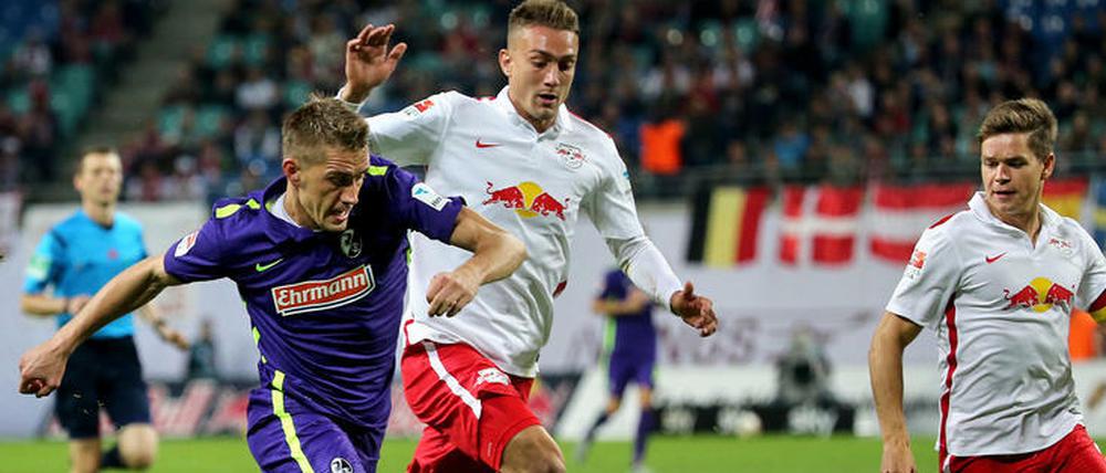 Dreikampf. Der Freiburger Stürmer Nils Petersen (l.) in Aktion gegen die Leipziger Stefan Ilsanker (Mitte) und Dominik Kaiser.