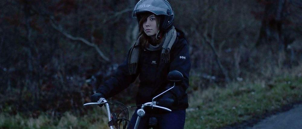 Sara auf einem Roller in der Dämmerung
