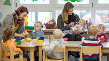 Die kleinsten Kinder des AWO Kindergartens «Diesterweg» in Lübbenau (Brandenburg) sitzen am 21.11.2014 beim Essen. Foto: Patrick Pleul/dpa (zu dpa «Tausende unterstützen Initiative für beitragsfreie Kita» vom 04.04.2015) +++(c) dpa - Bildfunk+++