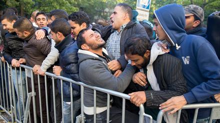 Flüchtlinge in Berlin auf dem Gelände des Landesamtes für Gesundheit und Soziales (LaGeSo) an einem Absperrgitter. Experten sehen in der Ansammlung vieler Menschen auf engem Raum eine Ursache für Aggressionen.