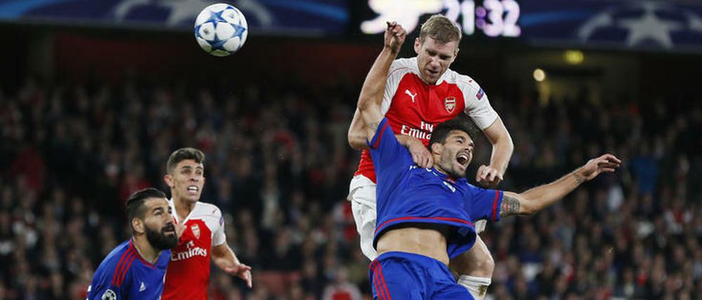 Per Mertesacker gewinnt zwar dieses Kopfballduell aber nicht das Spiel gegen Olympiakos.