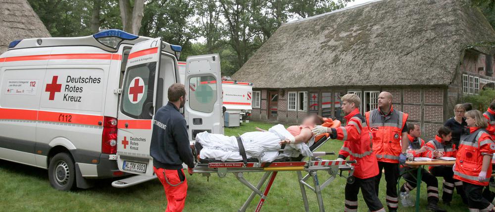 Eine verletzte Person wird auf einer Trage am 04.09.2015 in Handeloh (Niedersachsen) von Sanitätern zu einem Rettungsfahrzeug gefahren. Nach einer Massenvergiftung mit 29 Verletzten hat die Polizei die Strafverfahren gegen die Beteiligten eingeleitet. Sie werden beschuldigt, Halluzinogene eingenommen zu haben, sich selbst verletzt und somit einen Großrettungseinsatz verursacht zu haben.