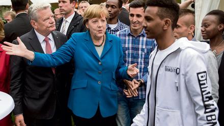 Bundeskanzlerin Angela Merkel (CDU) und Bundespräsident Joachim Gauck Mitte September 2015 beim Bürgerfest im Garten von Schloss Bellevue in Berlin mit Auszubildenden aus dem Verein «Ausbildung statt Abschiebung e.V.». 