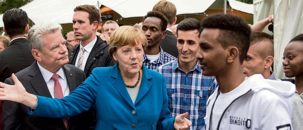 Bundeskanzlerin Angela Merkel (CDU) und Bundespräsident Joachim Gauck Mitte September 2015 beim Bürgerfest im Garten von Schloss Bellevue in Berlin mit Auszubildenden aus dem Verein «Ausbildung statt Abschiebung e.V.».