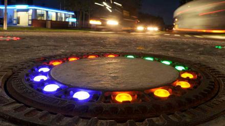 LED-Licht beleuchtetnun insgesamt fünf Gullydeckel auf einem Verkehrskreisel in Wallenhorst (Niedersachsen). Die farbigen Leuchten rund um die gusseisernen Deckel über den Kanalzugängen brachte dem Kreisverkehr die Spitznamen "Glühwürmchen-Kreisel" ein. Kostenpunkt: 10000 Euro. 