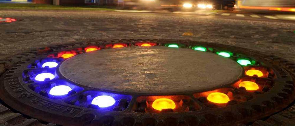 LED-Licht beleuchtetnun insgesamt fünf Gullydeckel auf einem Verkehrskreisel in Wallenhorst (Niedersachsen). Die farbigen Leuchten rund um die gusseisernen Deckel über den Kanalzugängen brachte dem Kreisverkehr die Spitznamen "Glühwürmchen-Kreisel" ein. Kostenpunkt: 10000 Euro.