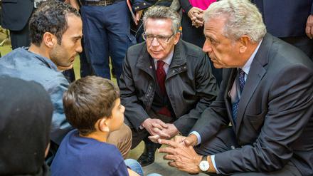 Bundesinnenminister Thomas de Maizière (CDU) spricht in einer Einrichtung der Bundespolizei in Rosenheim (Bayern) mit Asylbewerbern.