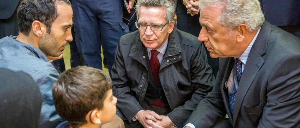 Bundesinnenminister Thomas de Maizière (CDU) spricht in einer Einrichtung der Bundespolizei in Rosenheim (Bayern) mit Asylbewerbern.